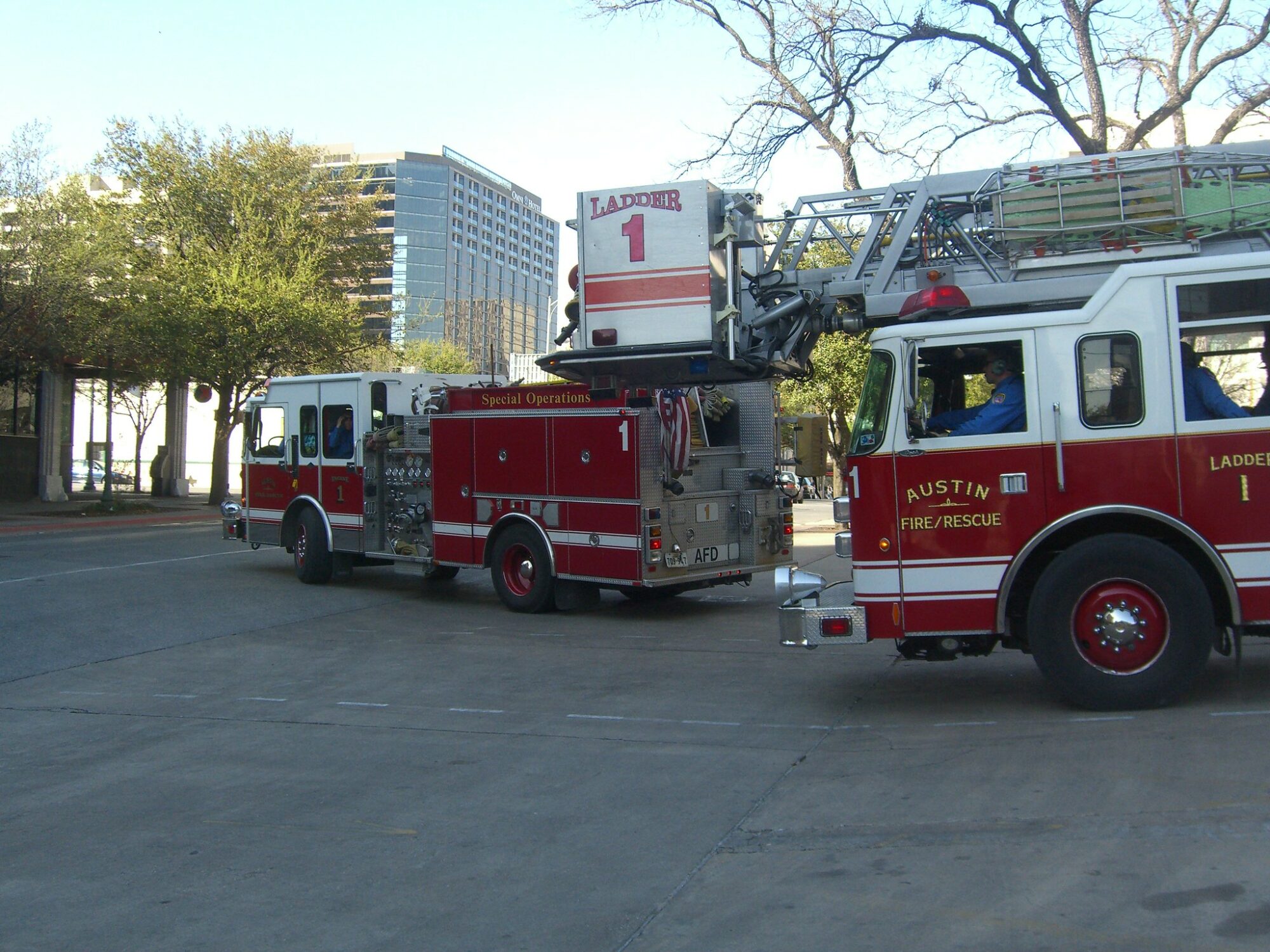 Two Austin Fire trucks pulling out of a fire station