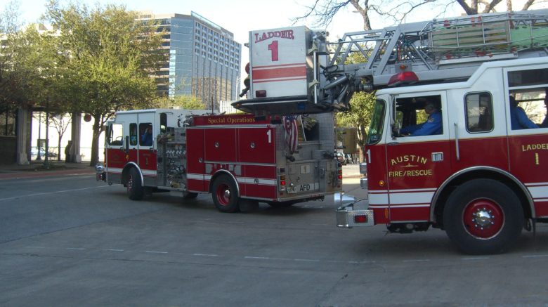 Two Austin Fire trucks pulling out of a fire station